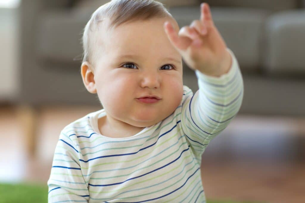 baby boy showing rock hand sign at home